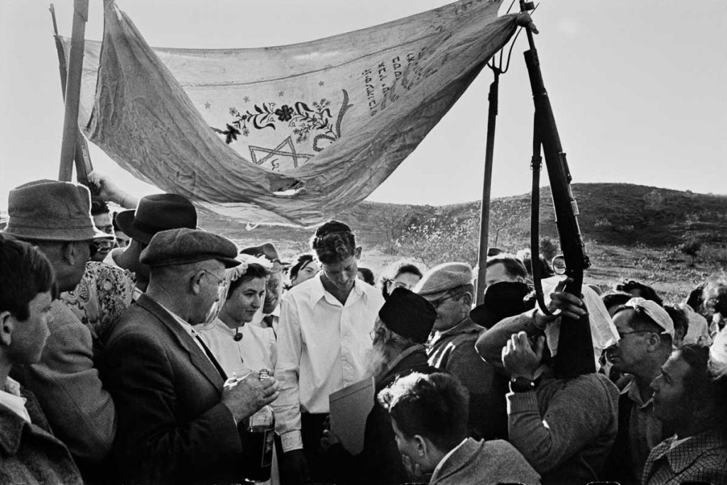 Wedding where the traditional wedding tent, or "huppah", is held up by improvised poles of guns and pitchforks. 1952.
